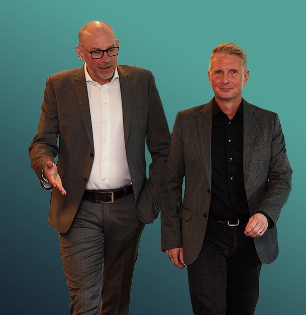 Two men in suits walking and talking against a teal gradient background.