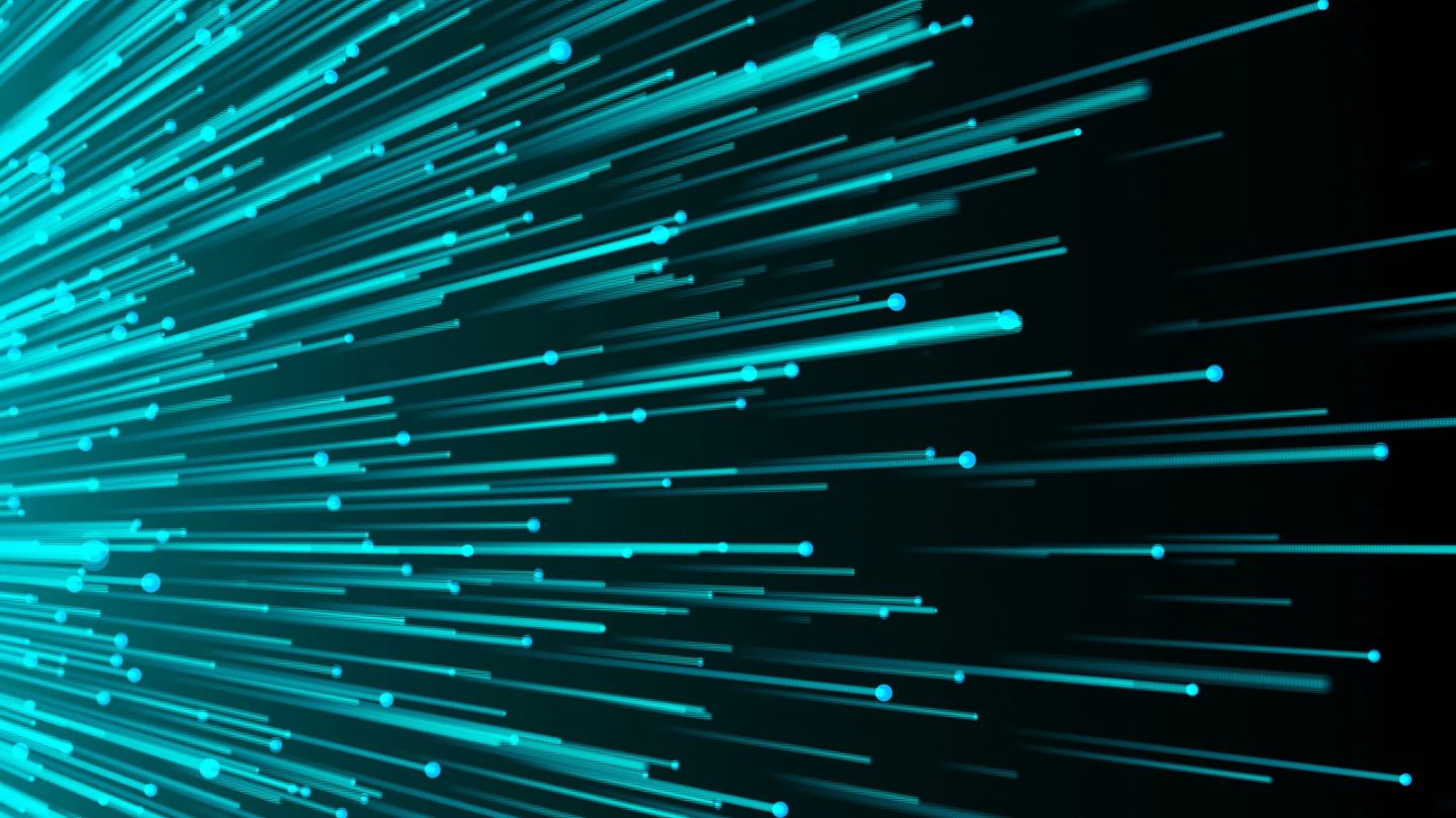 Blue glowing lines and dots streak diagonally across a dark background, resembling fibre optic cables or data streams.
