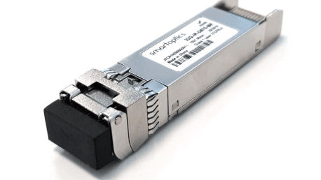 A close-up of a fibre optic transceiver module with a label and black connector cap.