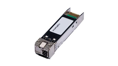 A close-up of a silver SFP fibre optic transceiver module with a white label and exposed connector.