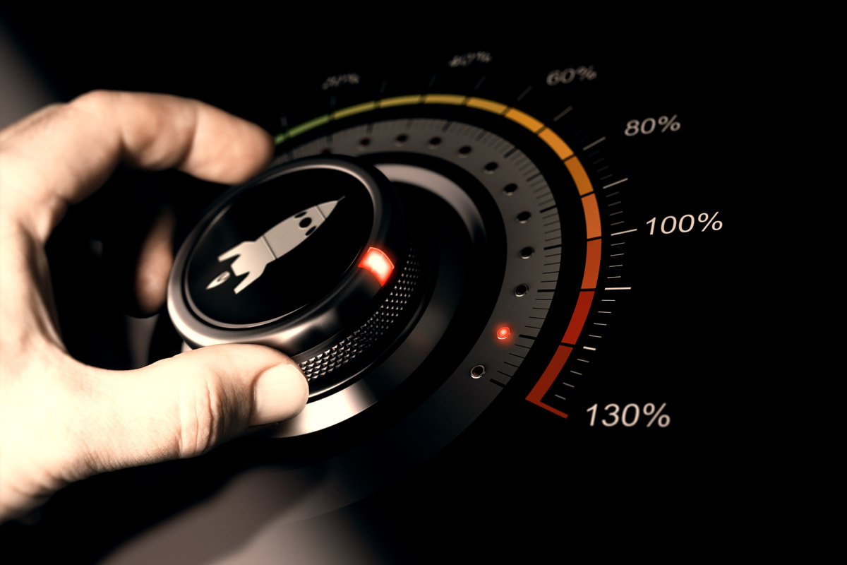Hand turning a dial with a rocket icon, gauge showing levels up to 130%, symbolising acceleration or boost.