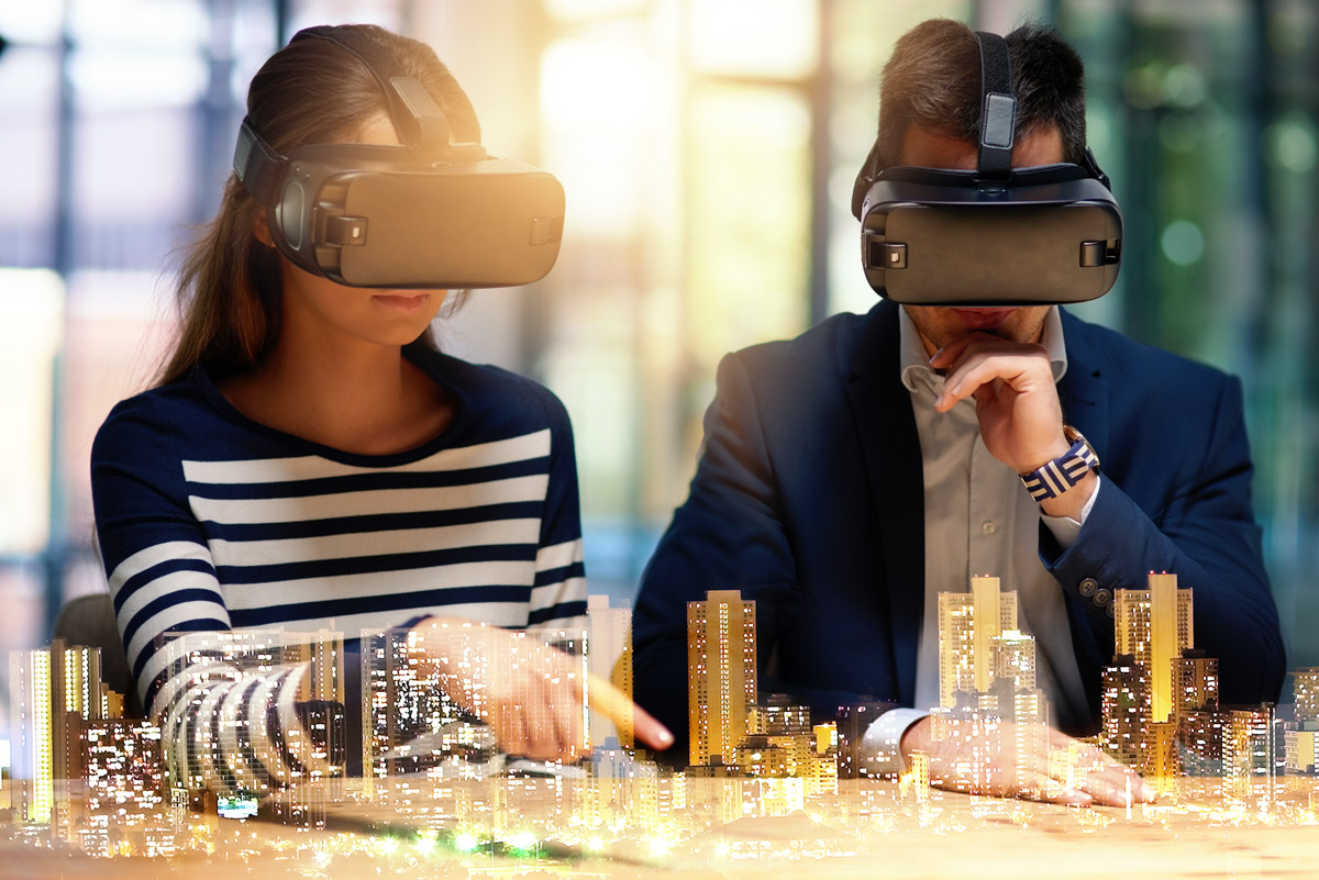 Two people wearing VR headsets interact with a virtual city model projected in front of them.